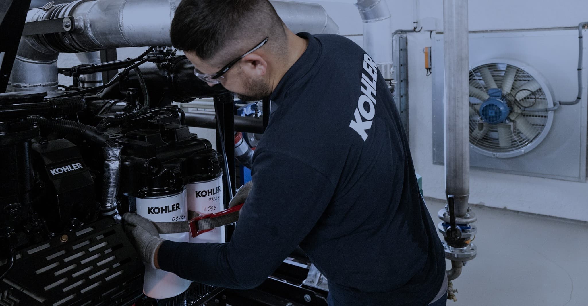 Technicien KOHLER en cours de maintenance sur un groupe électrogène.